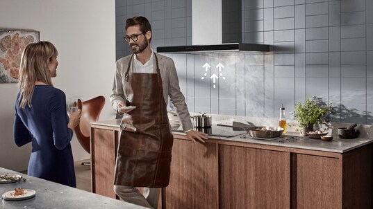 Man and woman in kitchen with illustration by the hood